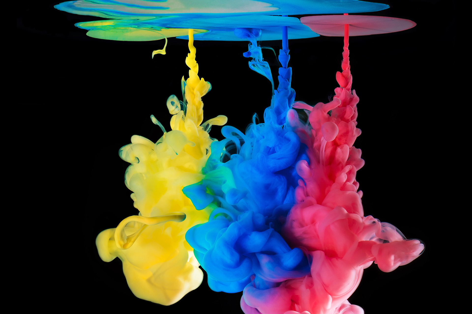 CMYK Gocce di inchiostro colorato in acqua con sfondo nero